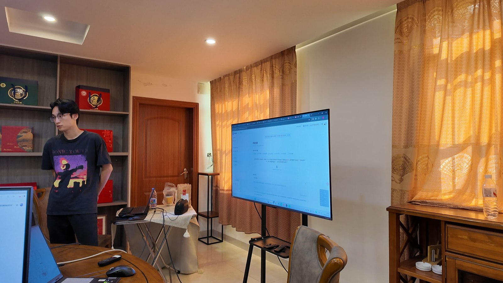 AI 培训现场，讲师在屏幕旁讲解 AI 工具的使用